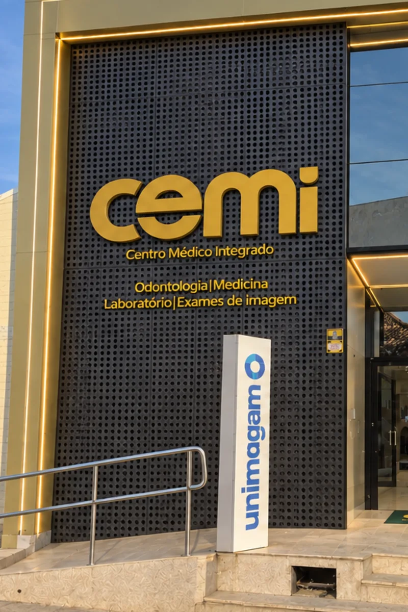Letreiro dourado da CEMI na fachada, com o totem da Unimagem ao lado da entrada