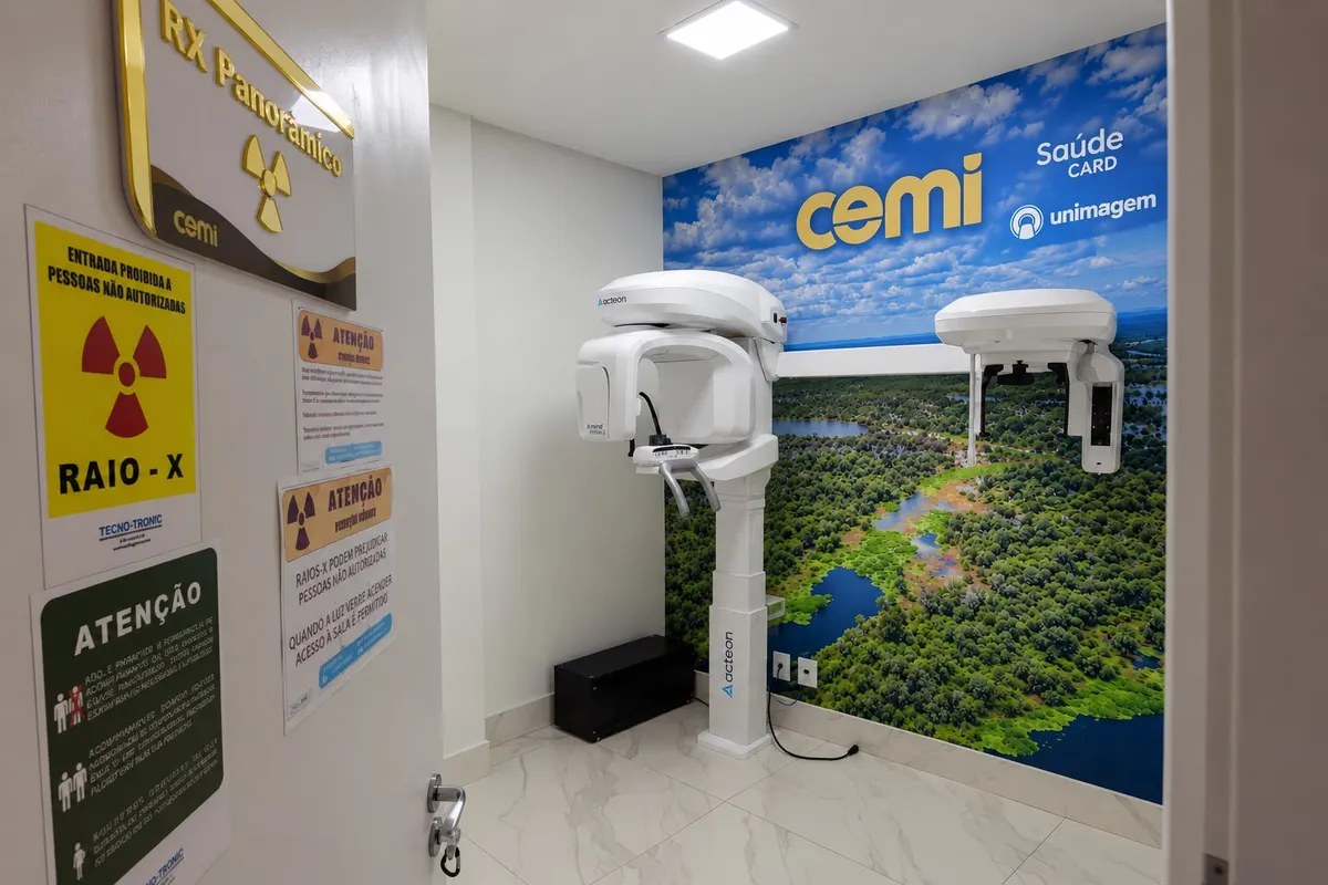 Entrada da sala de raio-X panorâmico da CEMI, com placa dourada e aparelho Acteon